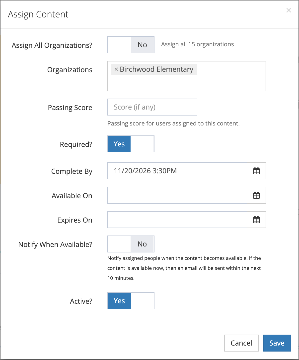 The Assign Content window with Assign All Organizations? set to No and Birchwood Elementary chosen, an empty Passing Score, Required? set to Yes, Complete By 11/20/2026 3, empty Available On and Expires On, Notify When Available? set to No, and Active? set to Yes.